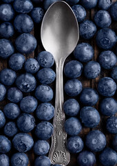 Blueberries around spoon close up photo. Natural healthy food. Still life photography