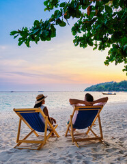 couple relaxing at a beach chair on the beach of Koh Lipe Thailand during sunset