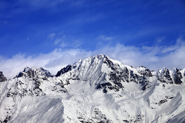 Fototapeta na wymiar Snow mountains in winter sun day and blue sky with clouds. View from ski lift on Hatsvali, Svaneti region of Georgia. Caucasus Mountains.