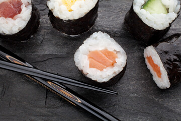 Sushi mit Stäbchen auf Schiefer