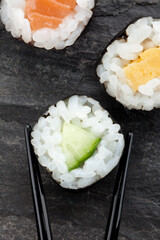 Sushi mit Stäbchen auf Schiefer