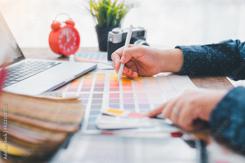 Fototapete Graphic designer architects who work with laptops and color comparison tables for design work..