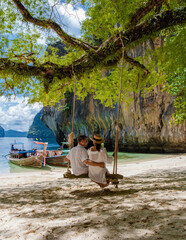 Couple on a boat trip to the Tropical lagoon of Koh Loa Lading Krabi Thailand part of the Koh Hong Islands in Thailand. beautiful beach with limestone cliffs and longtail boats