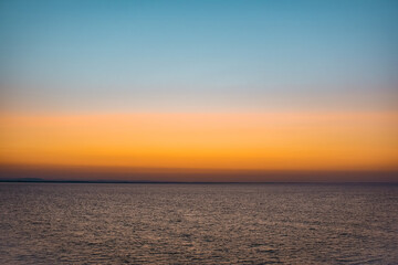 Sunrise sunset orange purple blue pink skies over ocean sea