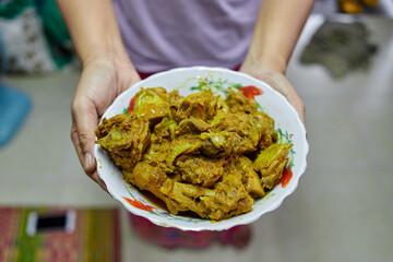 Midsection of woman holding spicy fried chicken meat in bowl