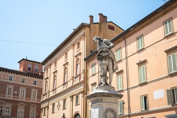 Obraz premium Monumento a Luigi Galvani statue in Bologna, Italy in a sunny day with historic houses