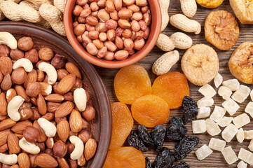 Different nuts and dried fruits on a wooden table. Almond, hazelnut, peanuts and cashew. Background with nuts and fruits.