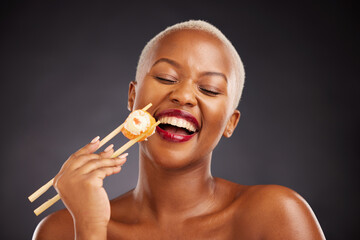 Face, laugh and woman with sushi and chopsticks in studio for healthy eating, beauty or food. Black female model with makeup on a dark background for wellness glow, diet nutrition or funny seafood - obrazy, fototapety, plakaty