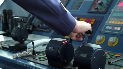 Motori avanti tutta. i comandi della nave.
Primopiano sulla mano del comandante che aziona i motori della nave.