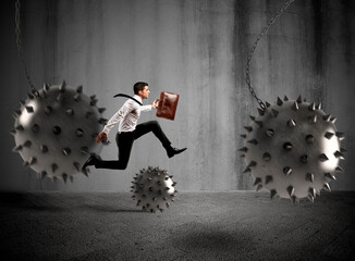 Businessman between fierce spiky balls that hinder