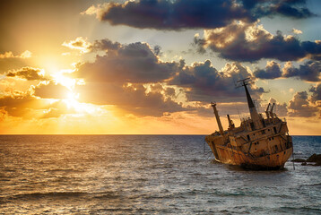 Seascape: boat EDRO III shipwrecked near the rocky shore at the sunset. Mediterranean, near Paphos. Cyprus