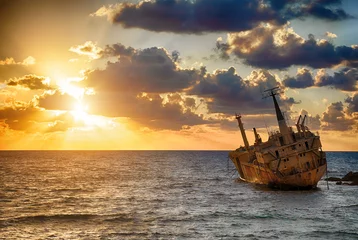 Fotobehang Seascape: boat EDRO III shipwrecked near the rocky shore at the sunset. Mediterranean, near Paphos. Cyprus © Designpics