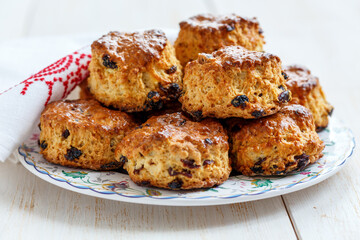 Scones with dried cranberries and raisins on a white wooden table.