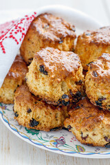 Homemade scones with dried berries on a white wooden table.
