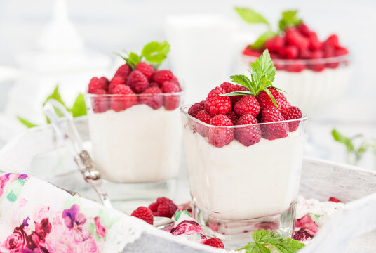 Delicious sweet creamy mousse  in a glass decorated with fresh raspberries