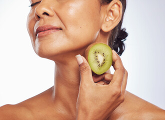 Beauty, skincare and mature woman with kiwi in studio isolated on a white background. Food, fruit...