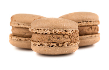 Three brown french macaroon cookies on white background