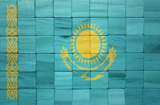 colorful painted big national flag of kazakhstan on a wooden cubes texture.