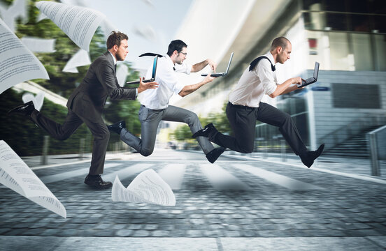 Businesspeople run on street to go to work with their laptop