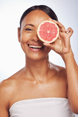 Skincare, face and mature woman with grapefruit in studio isolated on a white background. Portrait, natural fruit and happy model with food for nutrition, wellness and healthy diet for anti aging.