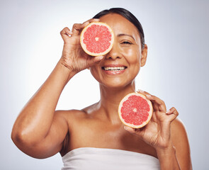 Face, happy and senior woman with grapefruit in studio isolated on a white background. Skincare, natural fruit and portrait of model with food for nutrition, healthy diet and vitamin c for anti aging