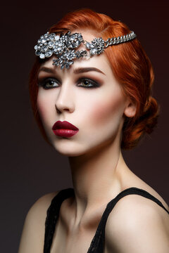 Beautiful young woman with smoky eyes and full red lips. Massive crystal hair accessory on head. Studio beauty shot. Copy space.