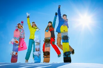 Jumping people with snowboards outdoors