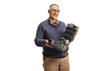Smiling mature man holding an orthopedic foot brace