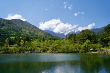 A quiet pond in Komagane City and the snowy Central Alps