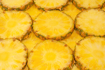 Pineapple juicy yellow slices as a background.