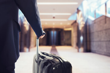 Businessman walking in the airport with suitcase
