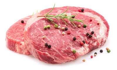 Raw ribeye steaks with peppercorn and rosemary isolated on white background. Closeup.