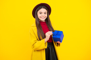 Happy teenager portrait in autumn hat and yellow coat. Autumn kids sale. Teenager child with gift box. Present for autumn holidays.