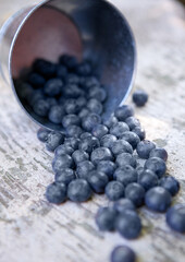 Blueberries in small steel bucket on grunge wooden board. Natural healthy food
