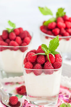 Delicious sweet creamy mousse  in a glass decorated with fresh raspberries