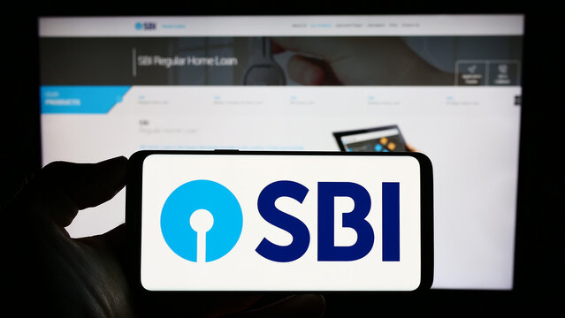 Stuttgart, Germany - 06-30-2023: Person holding mobile phone with logo of Indian company State Bank of India (SBI) on screen in front of business web page. Focus on phone display.