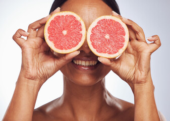 Smile, face and senior woman with grapefruit in studio isolated on a white background. Skincare, natural fruit and happy model with food for nutrition, healthy diet and vitamin c for anti aging.