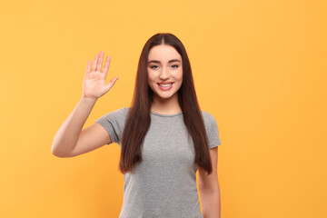 Happy woman giving high five on orange background