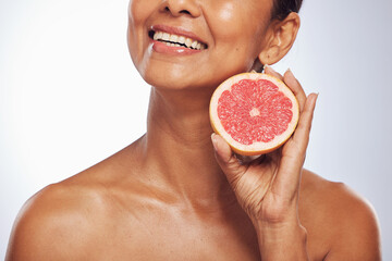 Skincare, beauty and happy woman with grapefruit in studio isolated on a white background. Food, natural fruit and hand of model with nutrition for wellness, healthy diet and vitamin c for anti aging