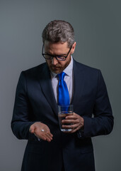 Tired, headache and eye strain. Businessman with stress, burnout and fatigue eyestrain. Business man rubbing tired eyes in studio. Man taking a medicine pill from headache migraine.