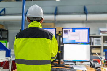 Inside the large Industry Factory Female Computer Engineer Works on Personal Computer She coding program for control machine,Thailand people work on fours monitors,Programmer working with serious