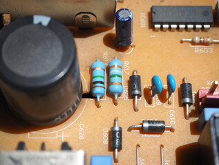 Electronic components on a industrial circuit board. Focused on resistors.