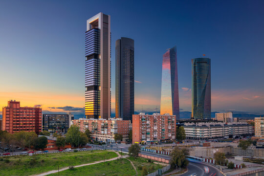 Image of Madrid, Spain financial district with modern skyscrapers during sunset.