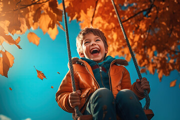 Little boy having fun on a swing on an autumn day