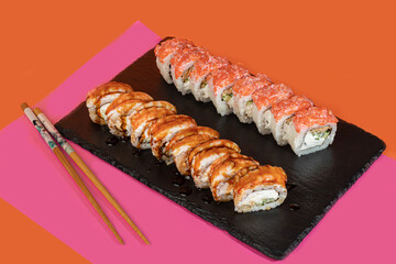 Sushi sets, rolls with caviar, shrimp, tuna and avocado and Philadelphia cheese, on a white plate.