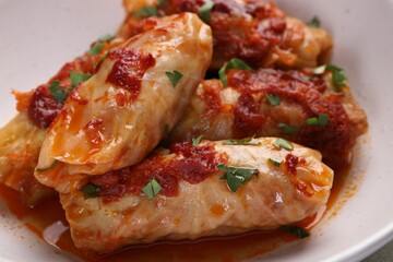 Delicious stuffed cabbage rolls cooked with homemade tomato sauce in bowl, closeup
