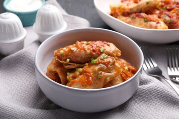 Delicious stuffed cabbage rolls cooked with homemade tomato sauce on table, closeup