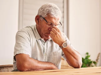 Photo sur Plexiglas Vielles portes Stress, headache and old man at table in home with glasses, worry and fatigue in retirement. Debt, anxiety and tired, frustrated senior person with mental health problem or crisis, exhausted and sad.