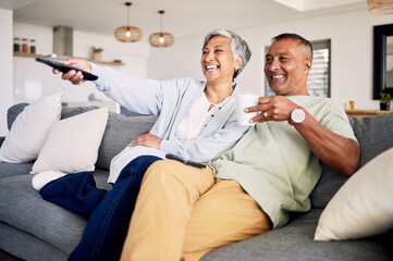 Fototapeta premium Senior couple, watching tv and relax on sofa in home living room, laughing and together for funny comedy show. Elderly man, old woman and happy for streaming comic movie on lounge couch in house