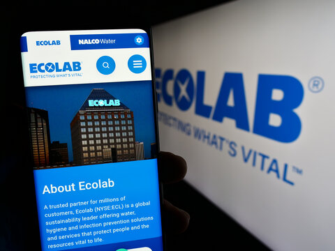 Stuttgart, Germany - 07-01-2023: Person holding cellphone with webpage of US water technology company Ecolab Inc. on screen in front of logo. Focus on center of phone display.